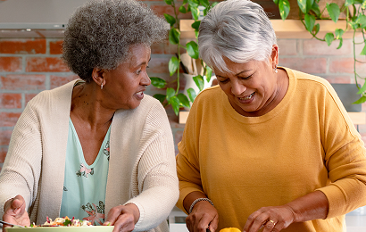 Actor portrayal of two elderly women enjoying a meal together