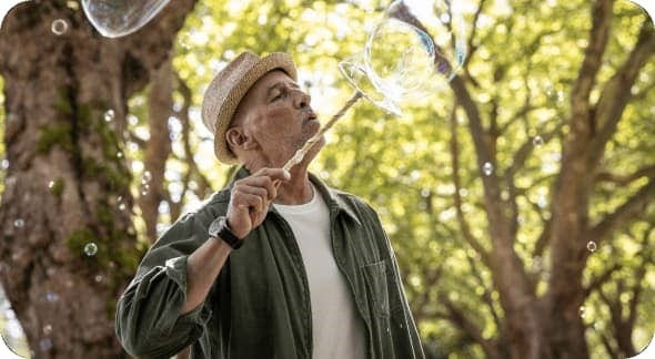 Older adult blowing bubbles outdoors