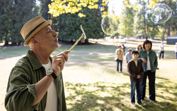 Older adult blowing bubbles outdoors