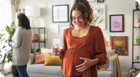 Pregnant woman standing and holding her stomach